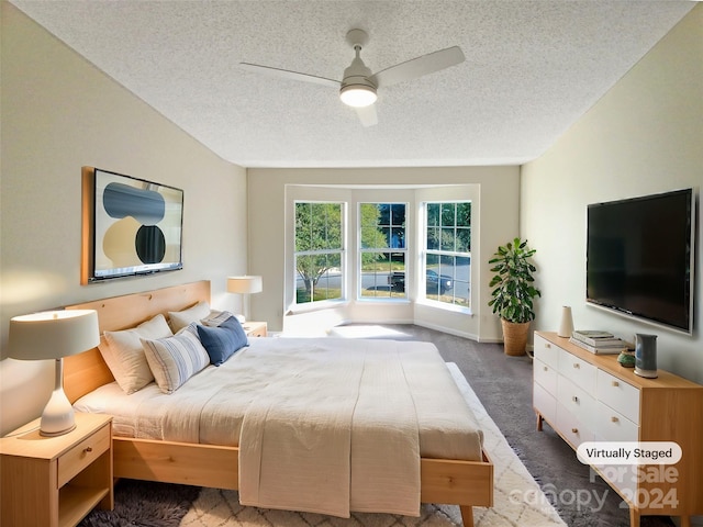 carpeted bedroom featuring ceiling fan and a textured ceiling