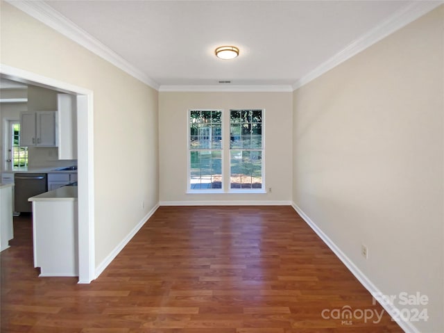 empty room featuring ornamental molding and dark hardwood / wood-style floors