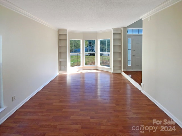 spare room featuring a textured ceiling, dark hardwood / wood-style floors, and crown molding