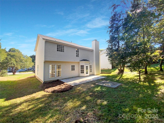 rear view of property featuring a yard and a patio area