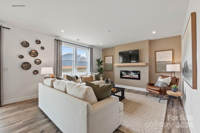 living room featuring a large fireplace and light hardwood / wood-style flooring