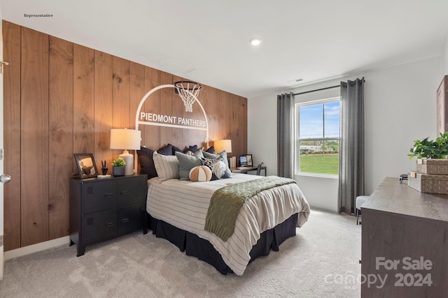 bedroom with wood walls and light colored carpet