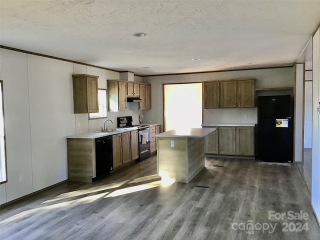 kitchen with dark hardwood / wood-style floors, black appliances, a wealth of natural light, and a kitchen island