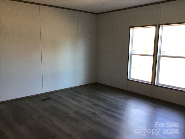 spare room with crown molding and dark hardwood / wood-style flooring