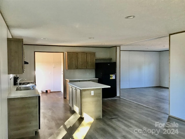 kitchen featuring sink, black refrigerator, hardwood / wood-style flooring, and a kitchen island