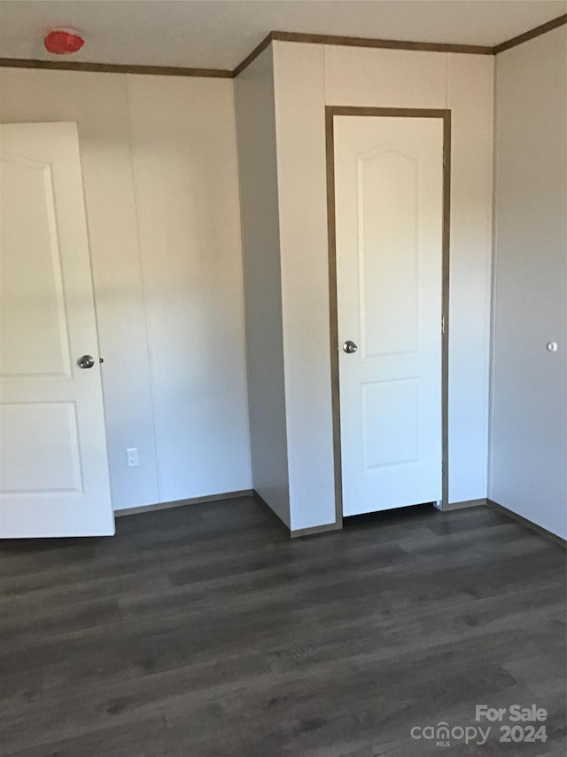 interior space featuring ornamental molding and dark hardwood / wood-style floors