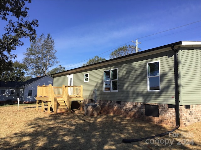 rear view of property featuring a wooden deck