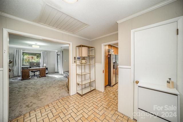 kitchen with ornamental molding, a textured ceiling, and stainless steel refrigerator with ice dispenser