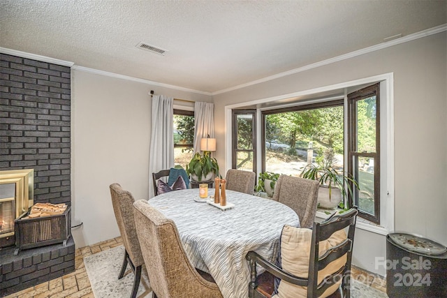 dining area featuring ornamental molding, a textured ceiling, and a brick fireplace