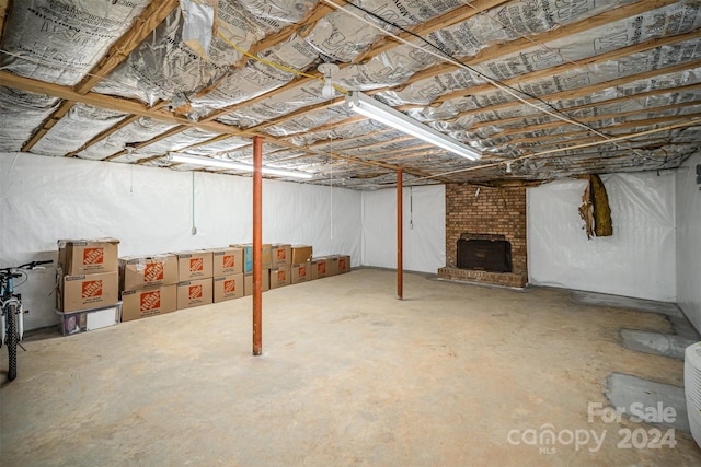 basement featuring a brick fireplace