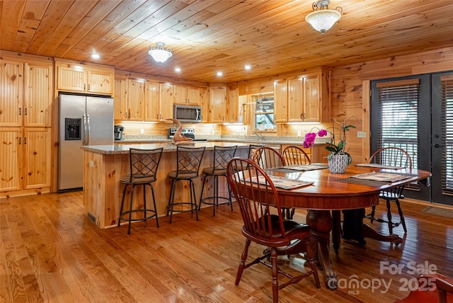 dining area featuring light hardwood / wood-style floors and wood ceiling