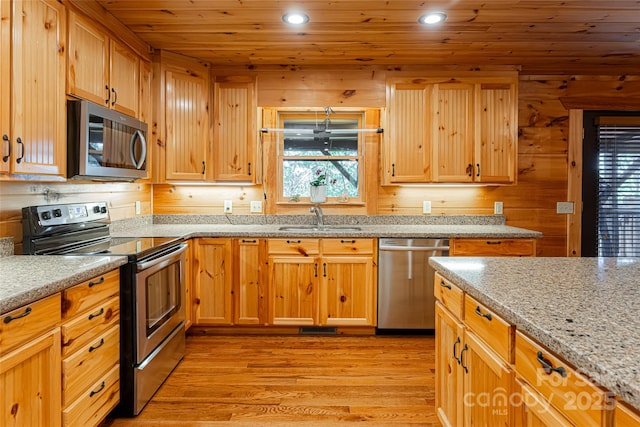 kitchen with sink, wooden ceiling, light stone counters, light hardwood / wood-style flooring, and appliances with stainless steel finishes