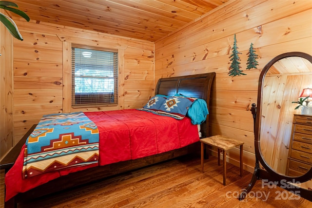 bedroom with hardwood / wood-style flooring, wood walls, and wood ceiling