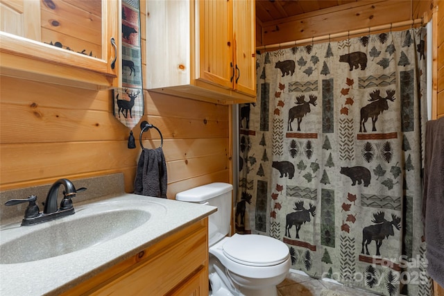 bathroom with a shower with shower curtain, tile patterned floors, vanity, toilet, and wood walls