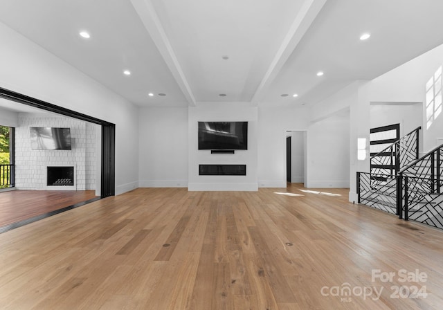 13702 Sage Thrasher Ln, Charlotte, NC 28278 - unfurnished living room featuring a fireplace, light wood-type flooring, beam ceiling, and recessed lighting