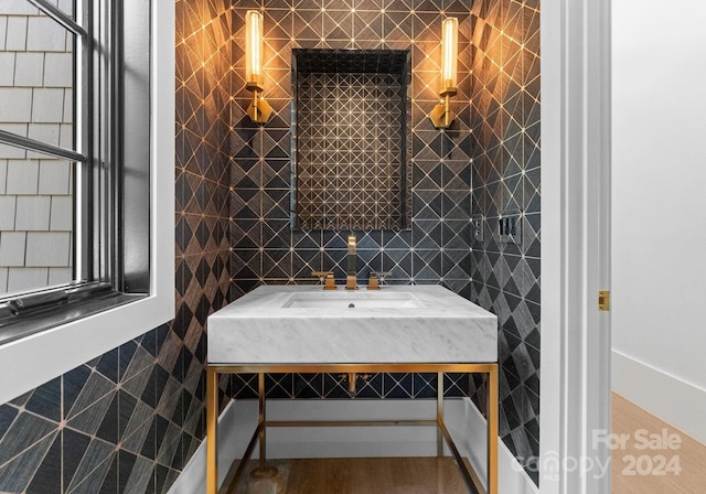 bathroom with hardwood / wood-style floors and tile walls