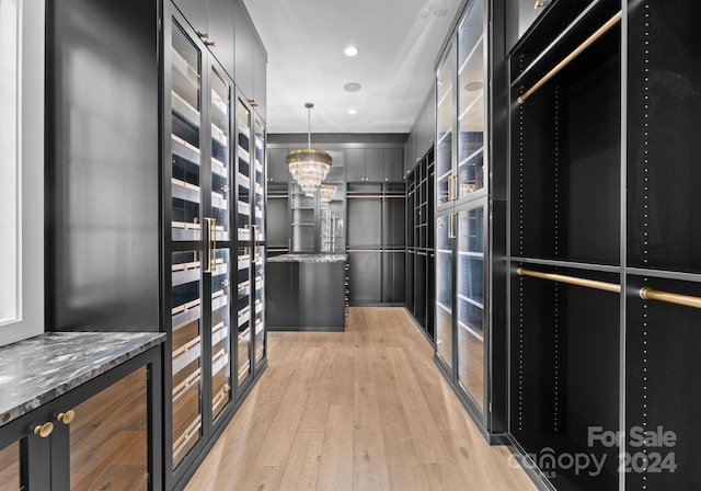 13702 Sage Thrasher Ln, Charlotte, NC 28278 - walk in closet featuring light wood-type flooring and a chandelier