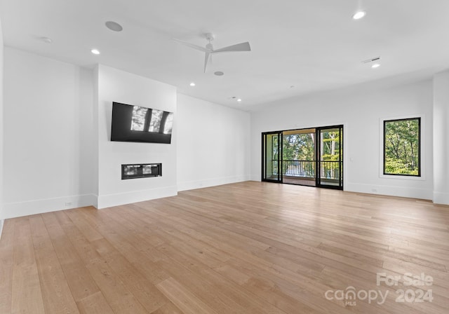 unfurnished living room with light wood-type flooring and ceiling fan