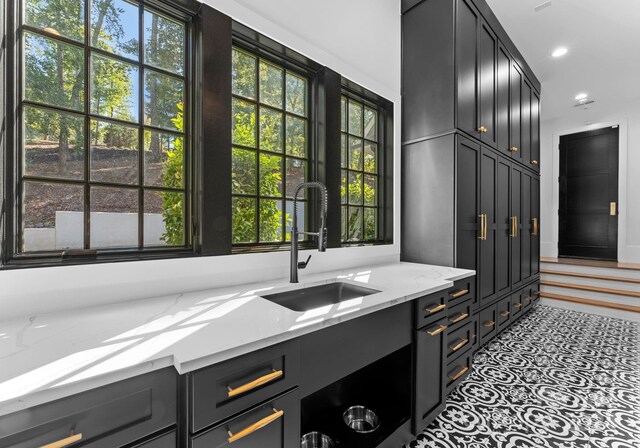 13702 Sage Thrasher Ln, Charlotte, NC 28278 - kitchen with light stone countertops, recessed lighting, and dark cabinetry