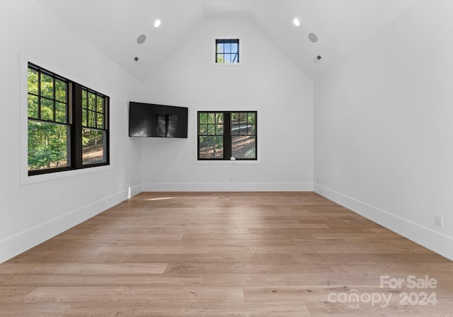 empty room featuring light hardwood / wood-style floors and high vaulted ceiling