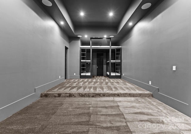 carpeted spare room featuring a tray ceiling