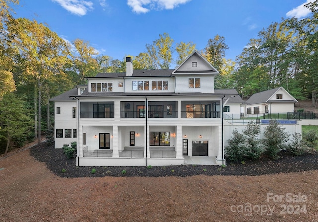 13702 Sage Thrasher Ln, Charlotte, NC 28278 - back of property with a chimney, a porch, and view of wooded area