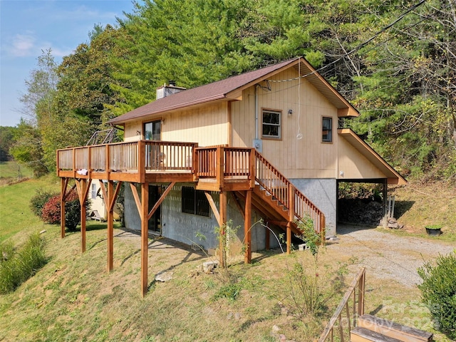 rear view of house with a yard and a wooden deck