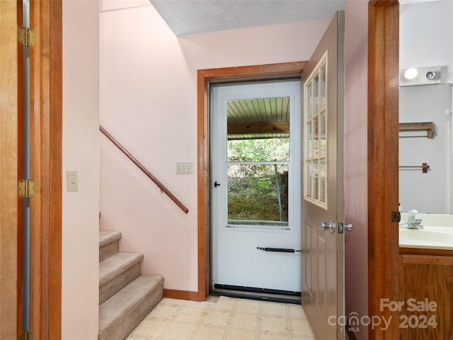 entryway with sink and a textured ceiling