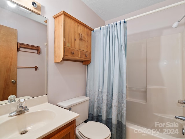 full bathroom featuring shower / bath combination with curtain, a textured ceiling, vanity, and toilet