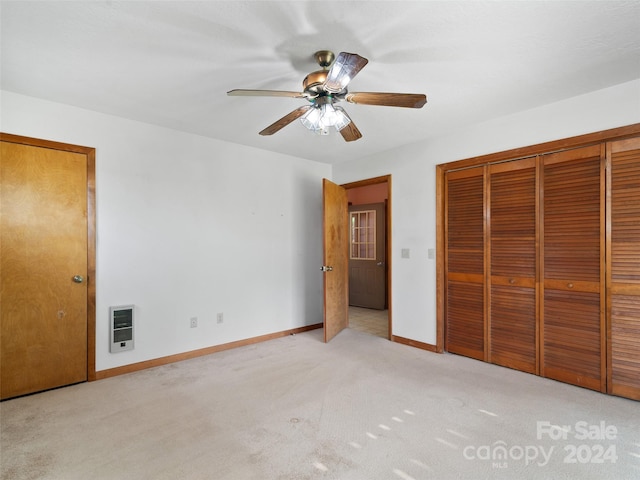 unfurnished bedroom with heating unit, ceiling fan, and light colored carpet