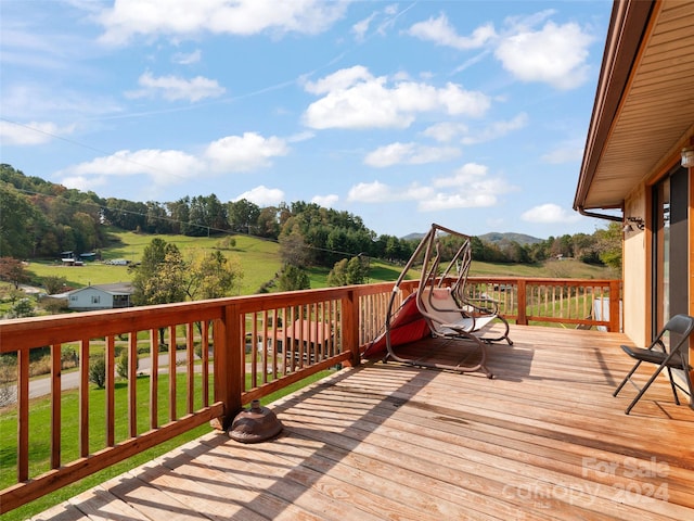 deck with a rural view and a yard