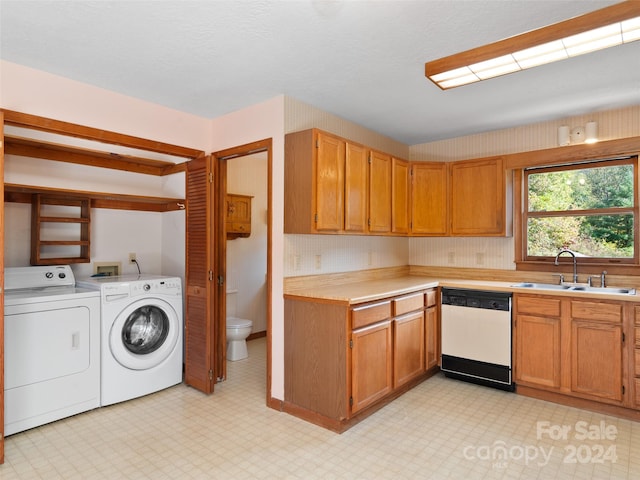 kitchen with white dishwasher, sink, and washing machine and dryer