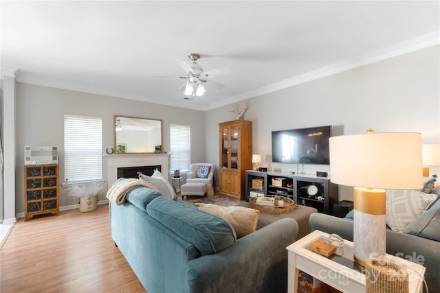 living room featuring ornamental molding, light wood-type flooring, and ceiling fan