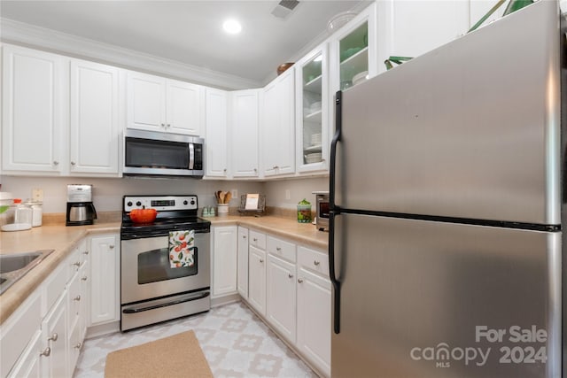 kitchen with appliances with stainless steel finishes, crown molding, and white cabinets