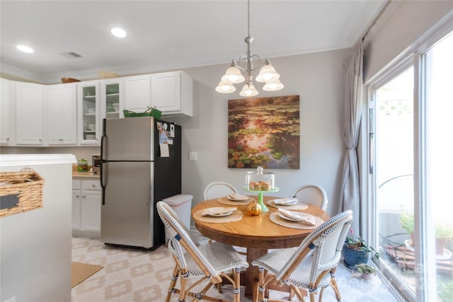 dining space with ornamental molding and an inviting chandelier