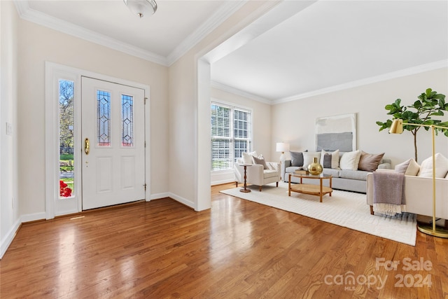 foyer entrance with ornamental molding, wood-type flooring, and plenty of natural light