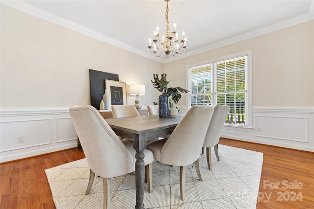 dining room with an inviting chandelier, ornamental molding, and wood-type flooring