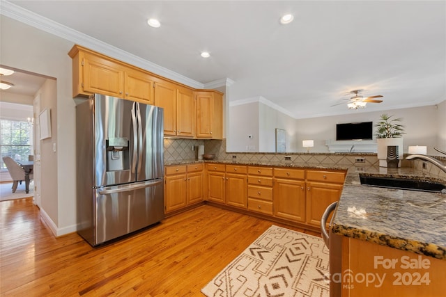 kitchen featuring ornamental molding, light hardwood / wood-style flooring, dark stone counters, and stainless steel refrigerator with ice dispenser