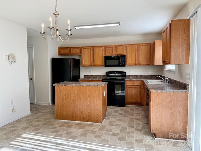 kitchen featuring dark countertops, a center island, a sink, black appliances, and a notable chandelier