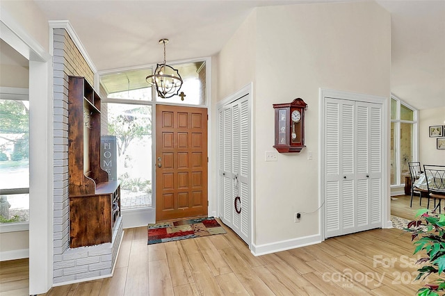 foyer with light hardwood / wood-style floors, a healthy amount of sunlight, and a chandelier