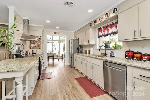 kitchen featuring wall chimney exhaust hood, stainless steel appliances, sink, light stone countertops, and light hardwood / wood-style floors