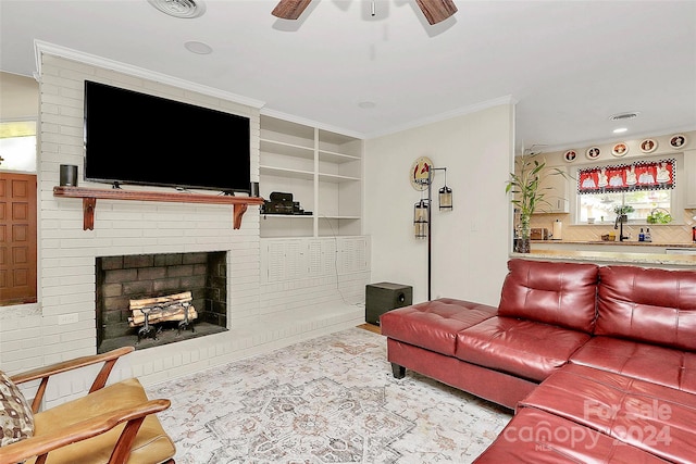 living room with ceiling fan, built in features, ornamental molding, and a fireplace