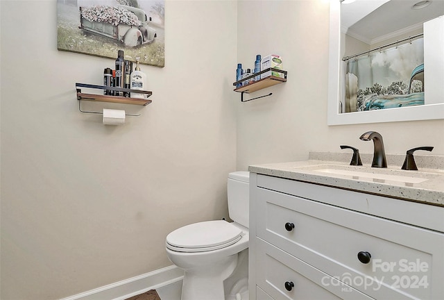 bathroom with vanity, toilet, and crown molding