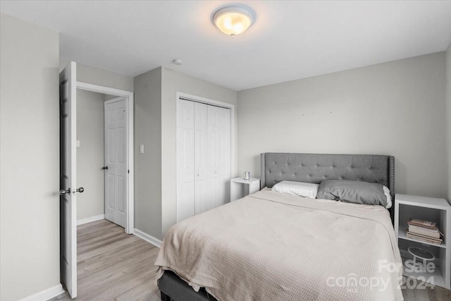 bedroom with light hardwood / wood-style flooring and a closet