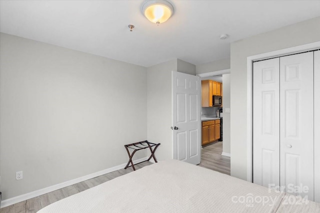 bedroom with a closet and light hardwood / wood-style flooring