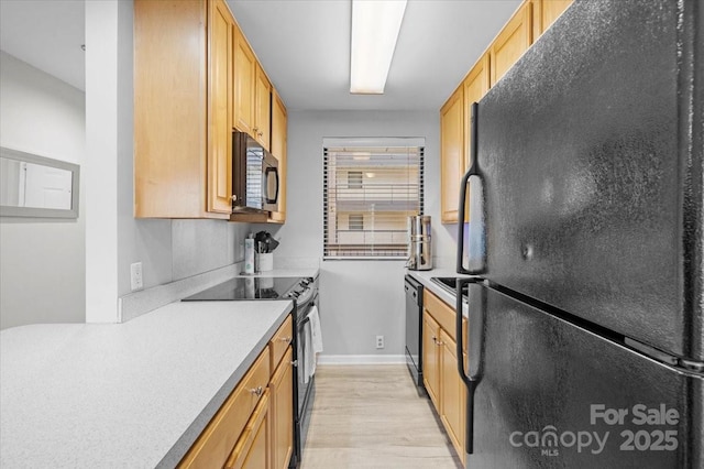 211 Heritage Blvd # 502, Fort Mill, SC 29715 - kitchen featuring black appliances, light countertops, light wood finished floors, and baseboards
