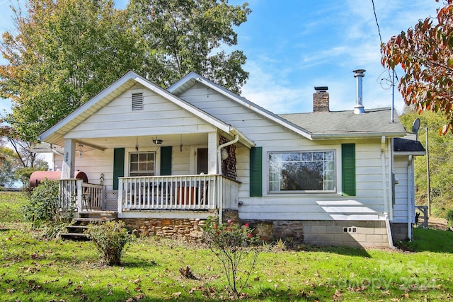 bungalow-style house featuring covered porch and a front yard