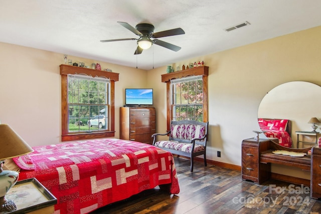 bedroom featuring dark hardwood / wood-style flooring, multiple windows, and ceiling fan