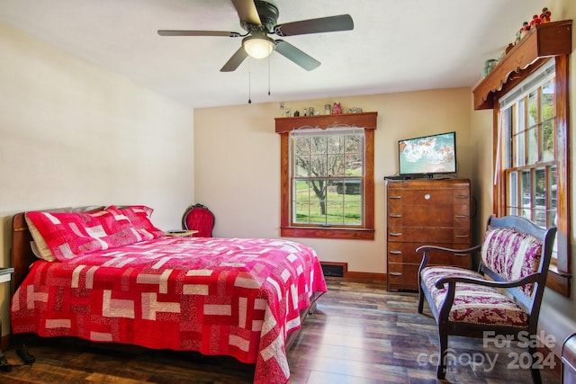 bedroom featuring dark wood-type flooring, multiple windows, and ceiling fan