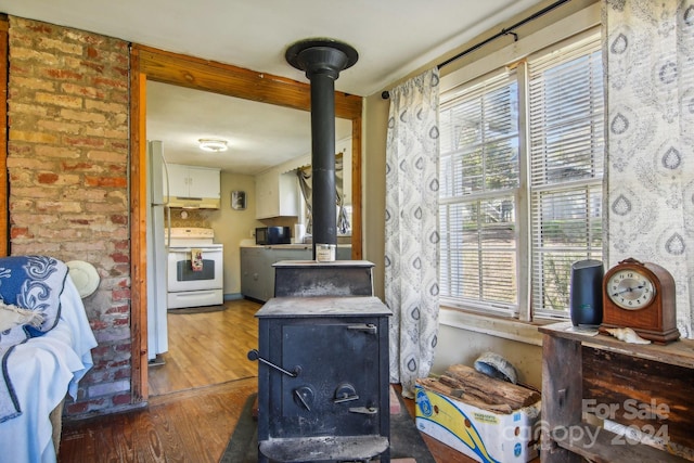 room details featuring a wood stove, hardwood / wood-style flooring, and white appliances